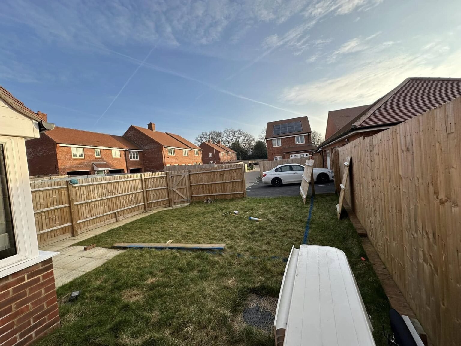 Composite decking with glass balustrade and integrated LED lighting in a Calcot contemporary extension, expertly installed by AJR Landscaping.
