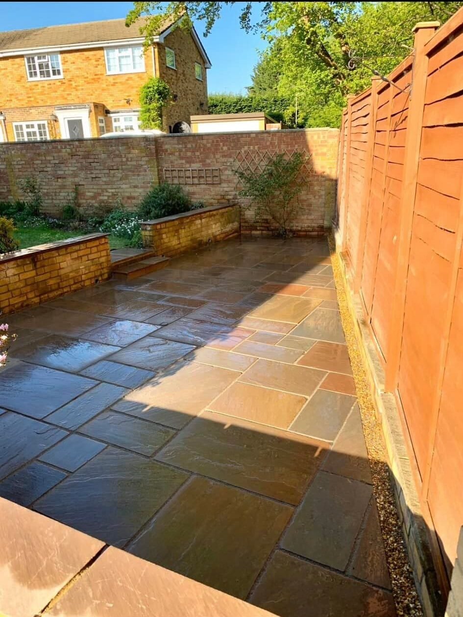 Bespoke patio with durable sandstone paving and raised planting beds for Newbury gardens, installed by AJR Landscaping.