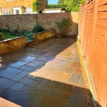 Bespoke patio installation with durable sandstone paving and raised planting beds in Newbury. AJR Landscaping delivers custom patio solutions for clients in Newbury and the Berkshire region.